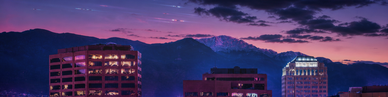 Colorado Springs downtown at dusk with backlit Pikes Peak and the Front Range.