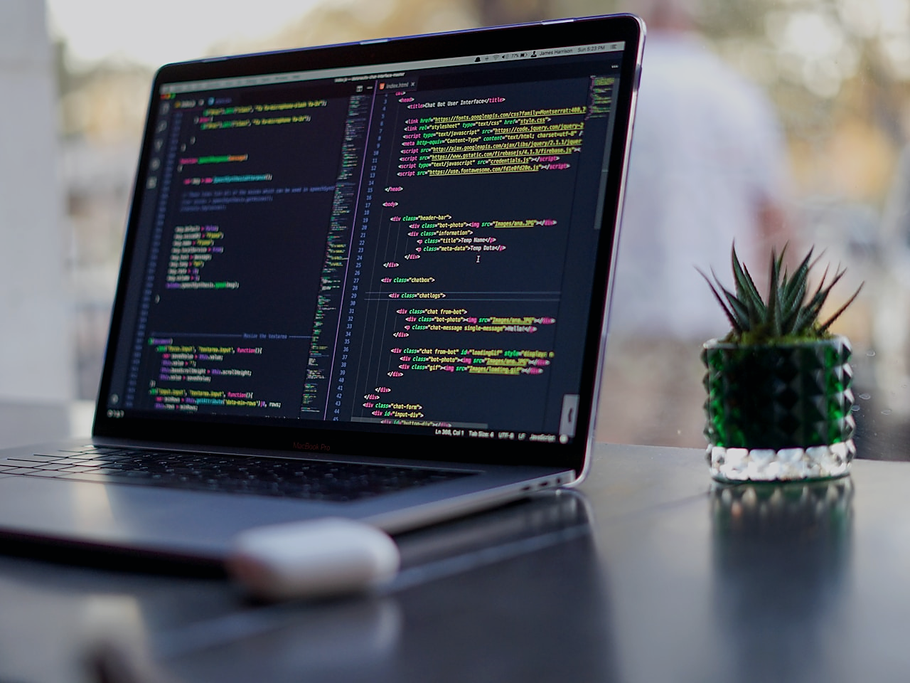 Engineer at a modern workstation with code on screen, representing network and web development services.